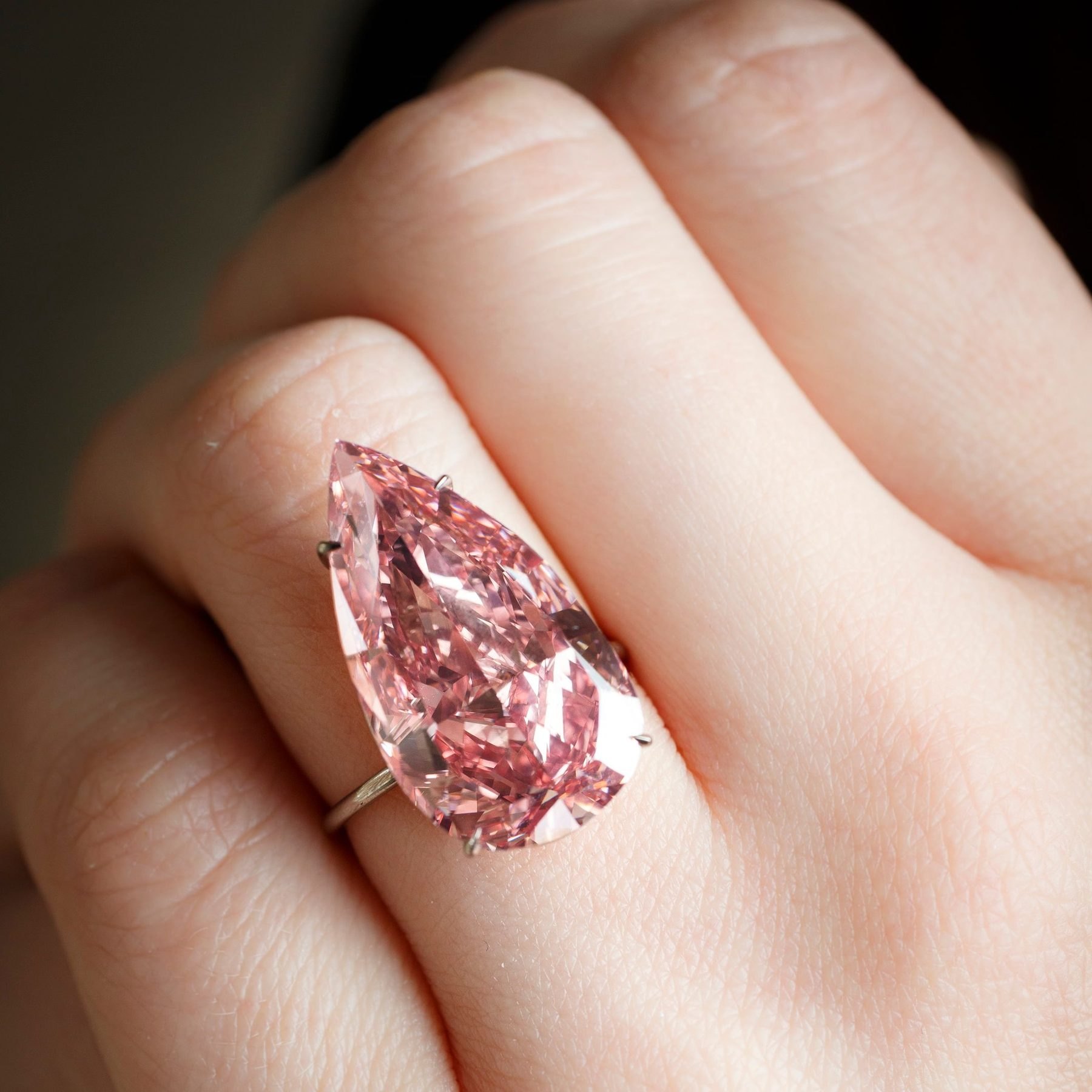 Pink pear-shaped diamond ring on a hand